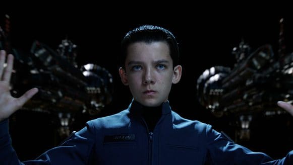 Boy in a futuristic outfit with hands raised, two spacecraft in the background