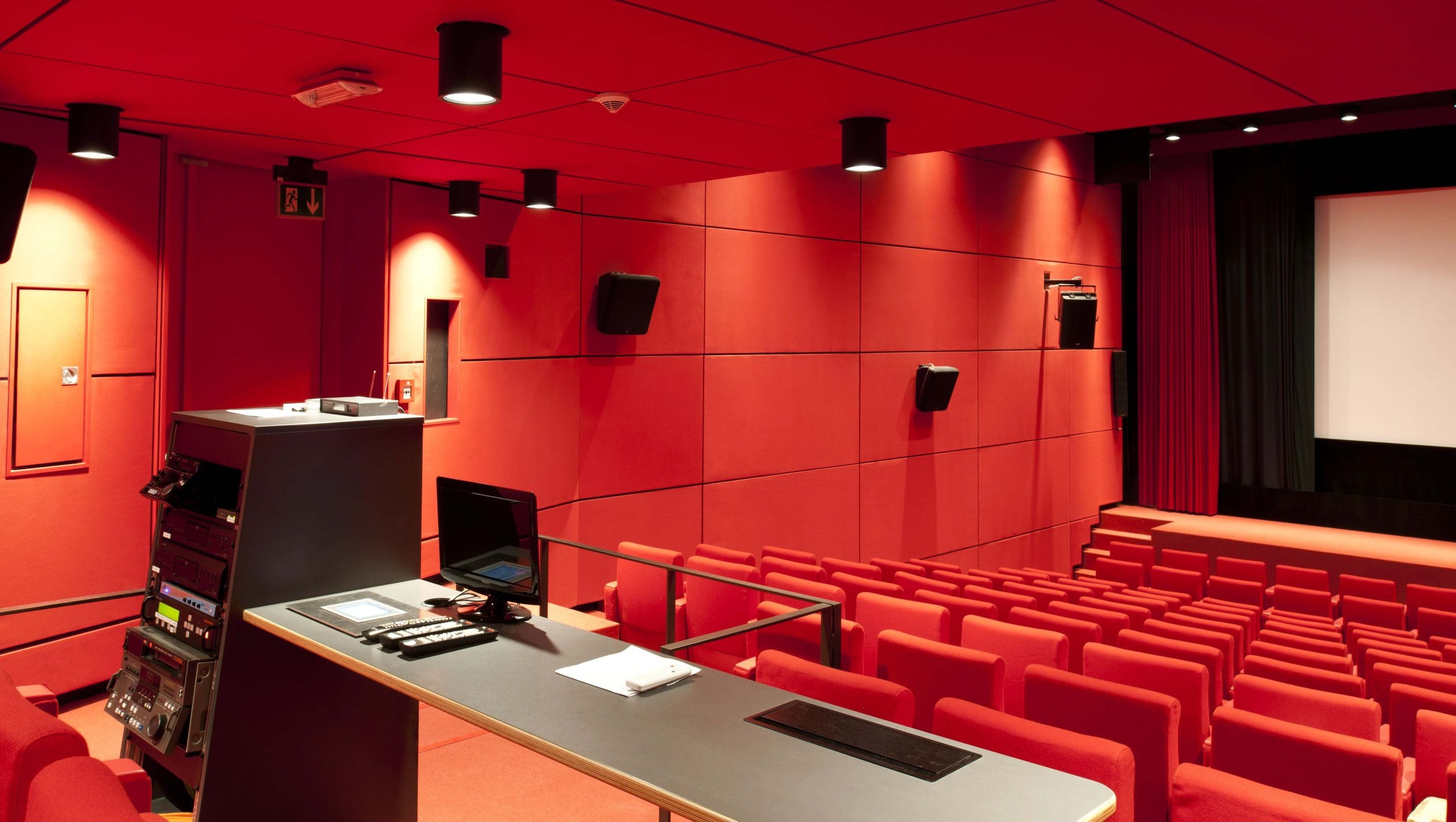 Empty red theater with audio equipment and rows of seats