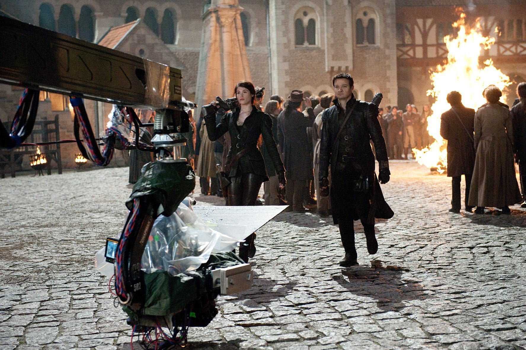 Film crew shooting a scene with actors on a cobblestone street