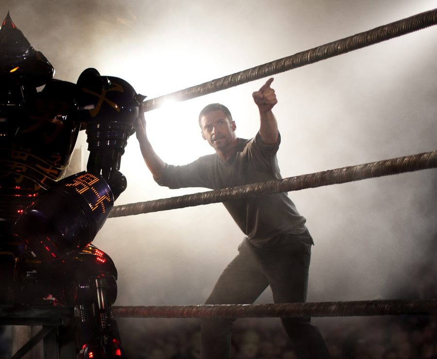 A man interacting with a robot in a boxing ring