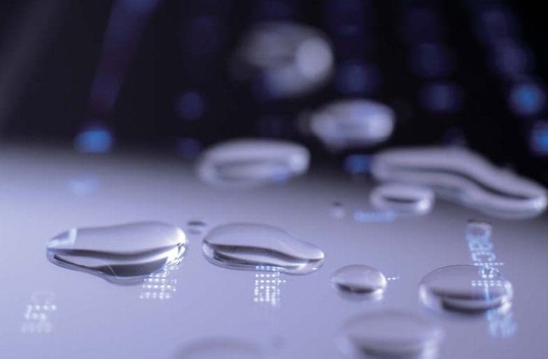 Water droplets on a black keyboard surface.