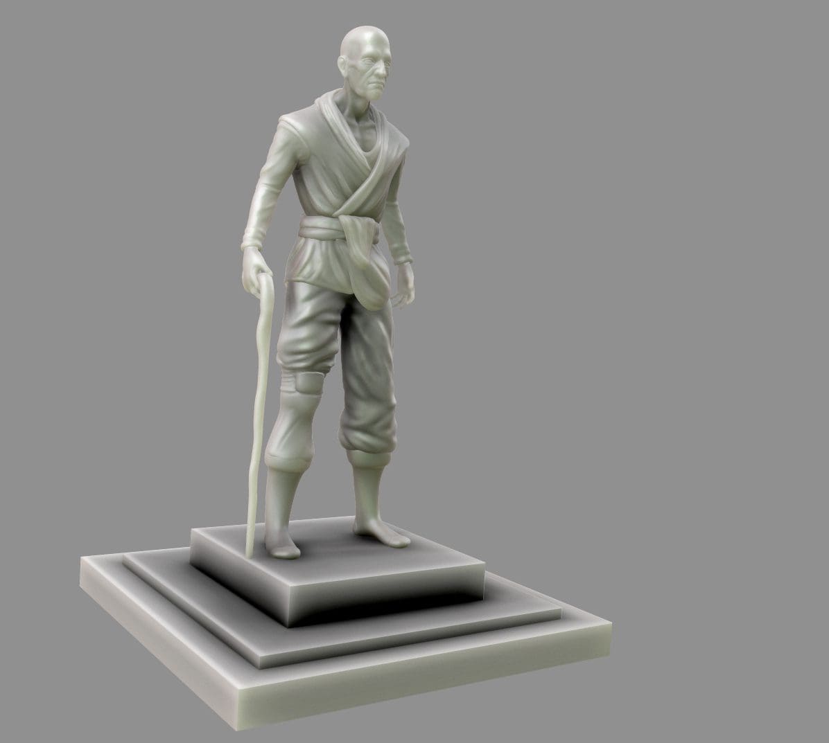 A gray statue of a standing figure with a cane, wearing a robe and trousers, on a square pedestal.