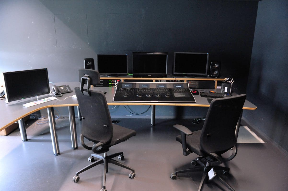 Control room with two chairs and multiple screens
