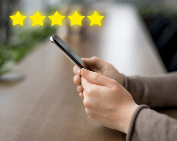 A person using their phone leaving a 5 star review.