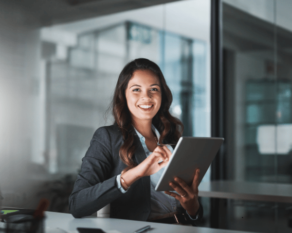 A happy marketer using an audio video editor on her laptop.