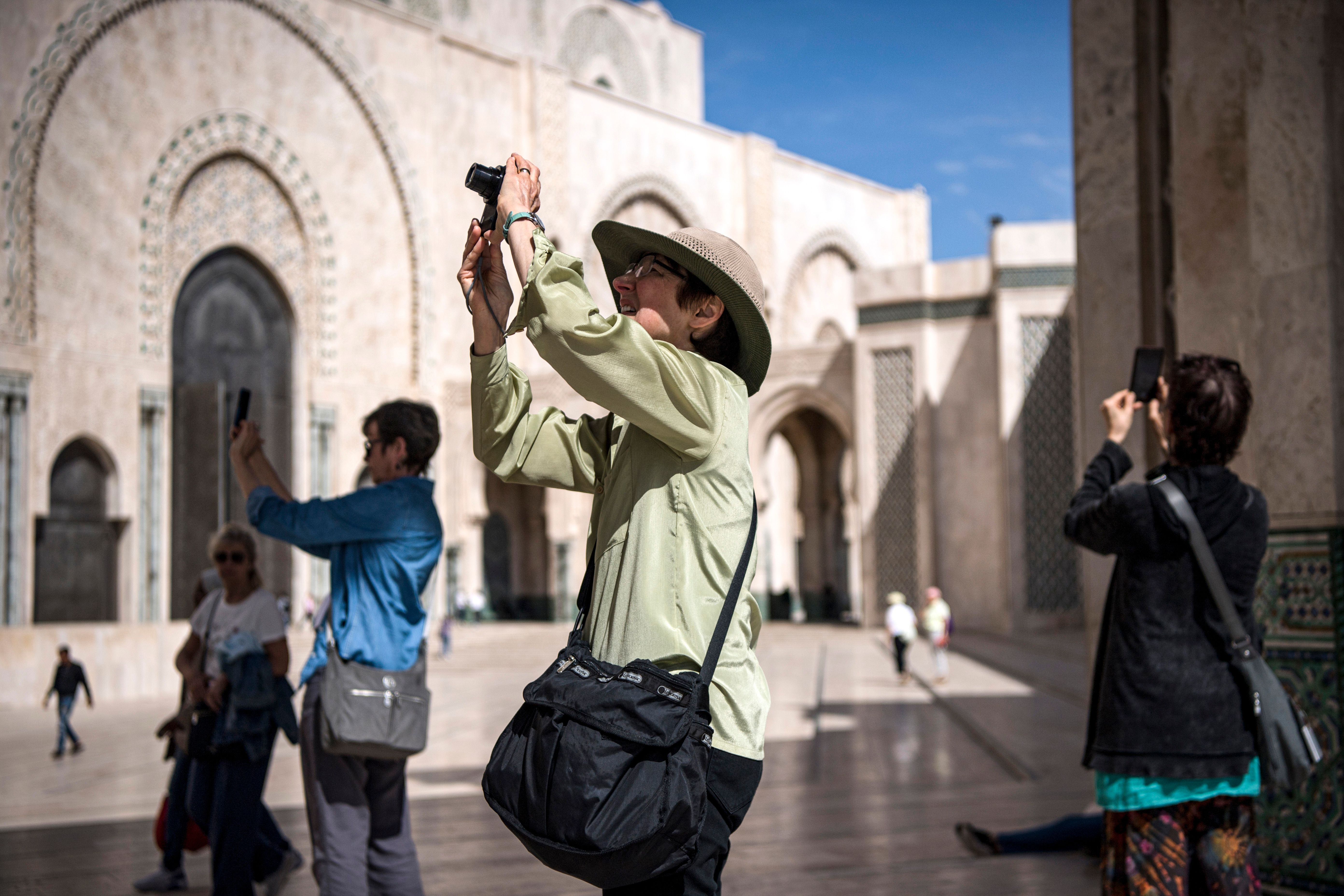 Tourists take pictures with their phones and cameras while visiting the Hassan II Grand Mosque in Morocco's Casablanca on March 12, 2020. (Photo by FADEL SENNA / AFP) (Photo by FADEL SENNA/AFP via Getty Images)