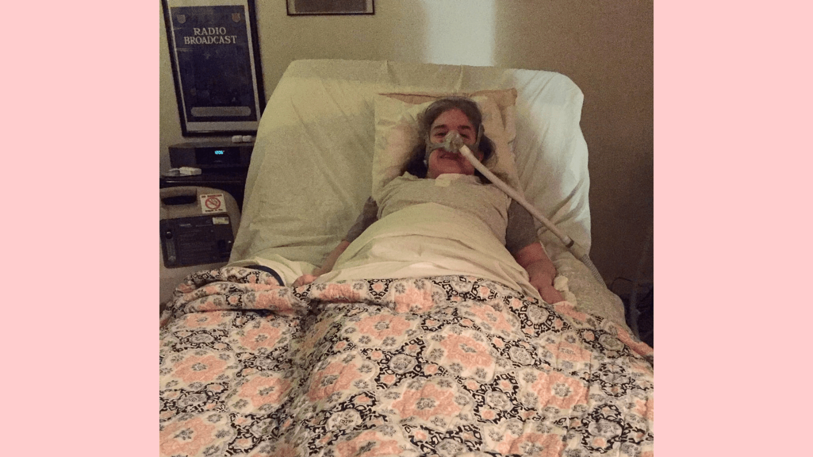 Graphic with a light pink background. In the center, a photo of Ingrid Tischer of her first day home from the hospital. Ingrid is a middle-aged white woman wearing a Bi-Pap mask in a hospital bed under a colorful quilt.