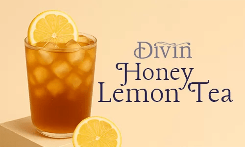 a glass of iced divin honey lemon green tea on a podium with lemon slices beside it
