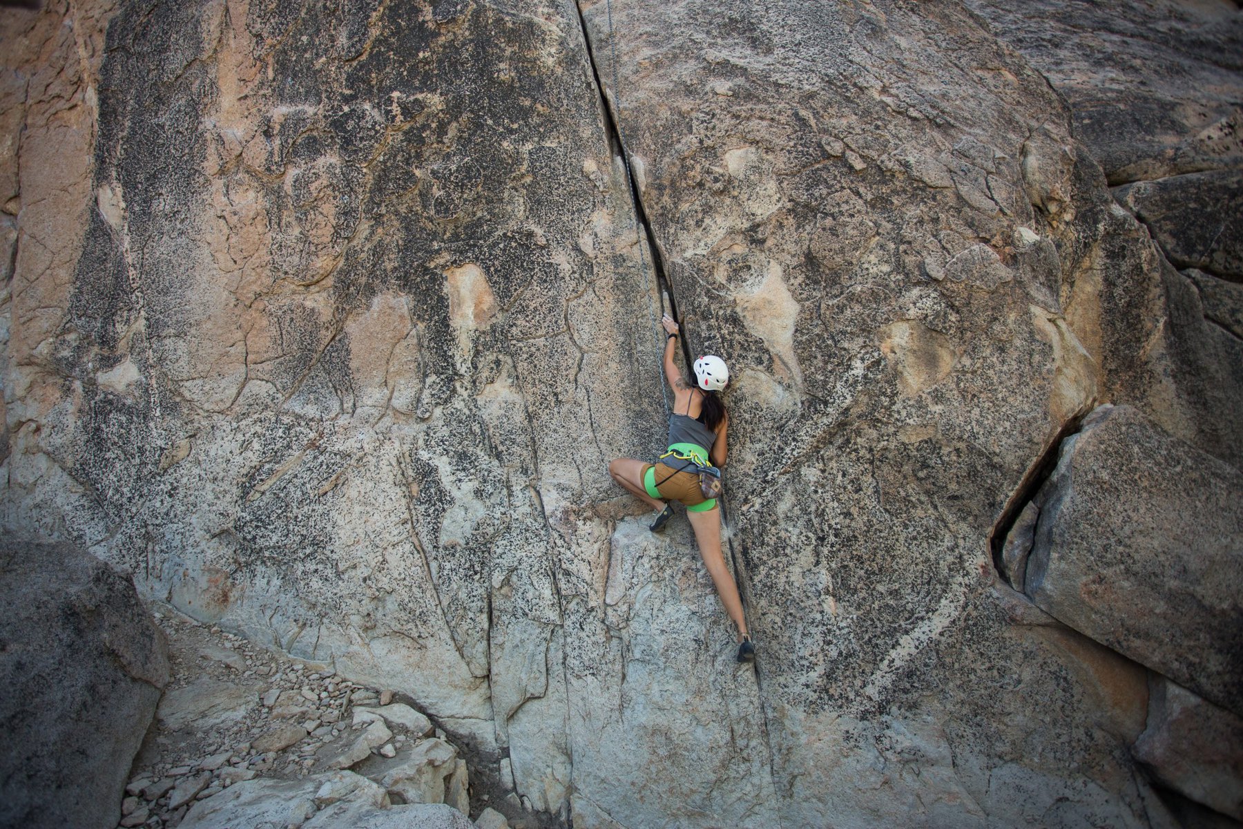 A woman scaling a rock cliff as an example of trying new things after divorce