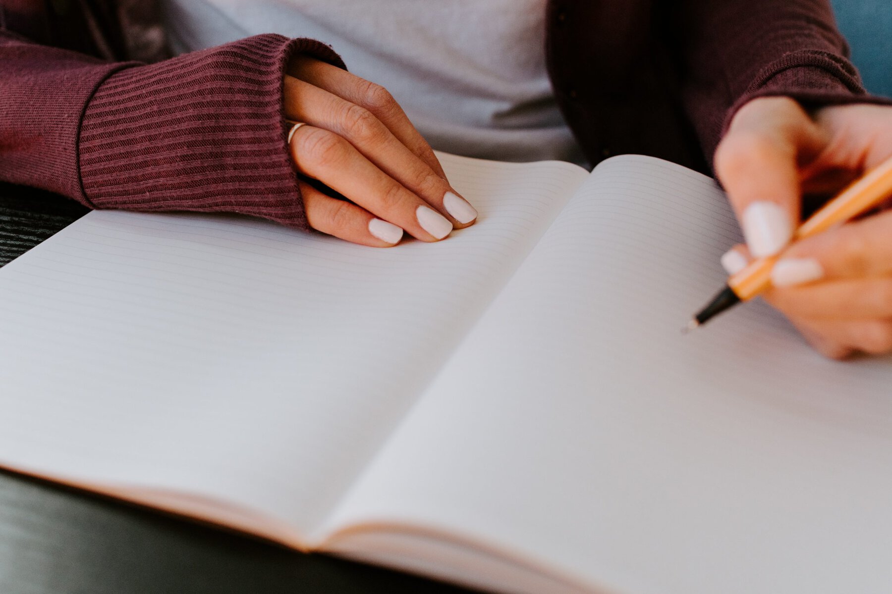 A women writing in her journal - one of the seven basic good habits for the new year we share today.