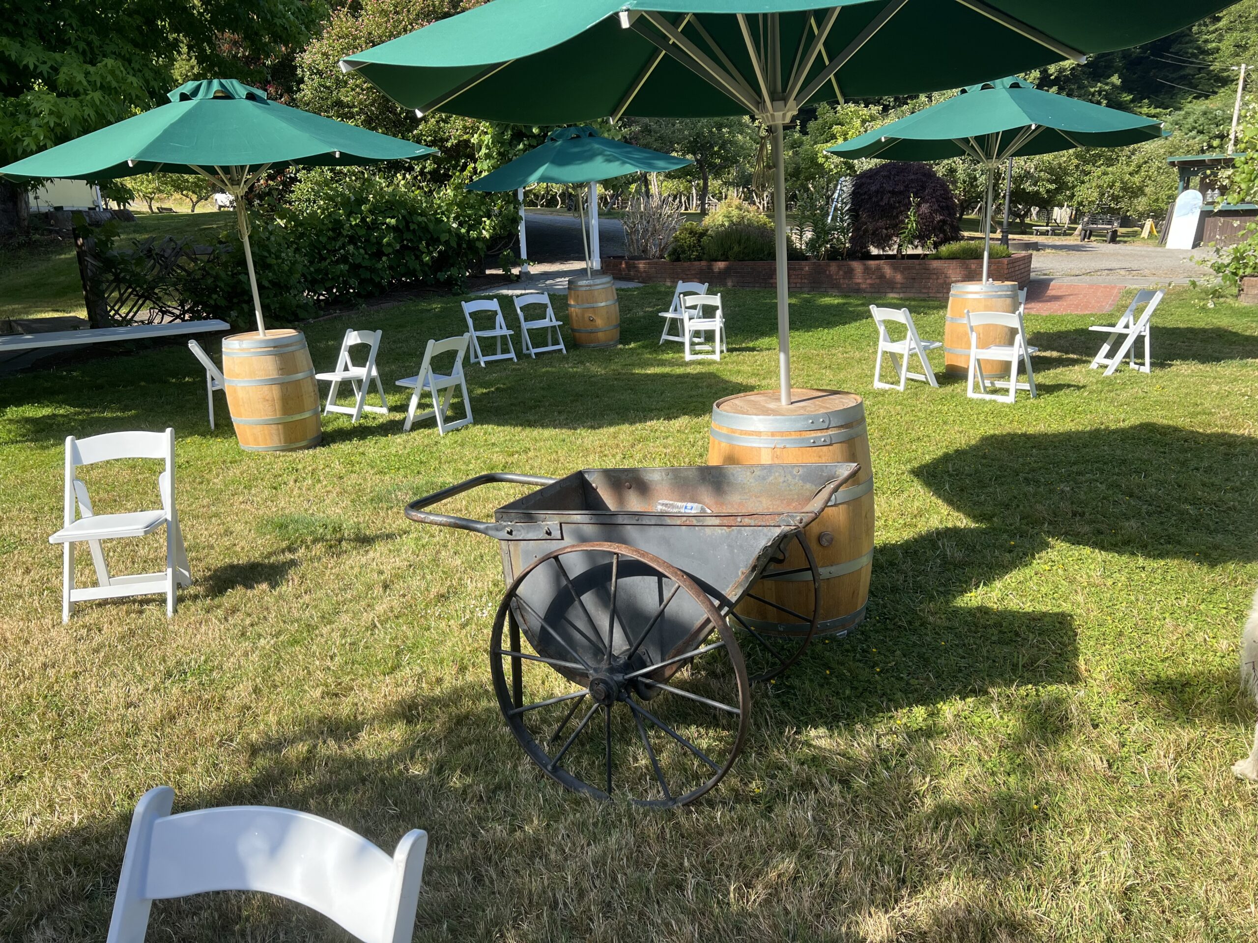 Colorful outdoor wedding lounge with mismatched chairs, cocktail tables and bright umbrellas.