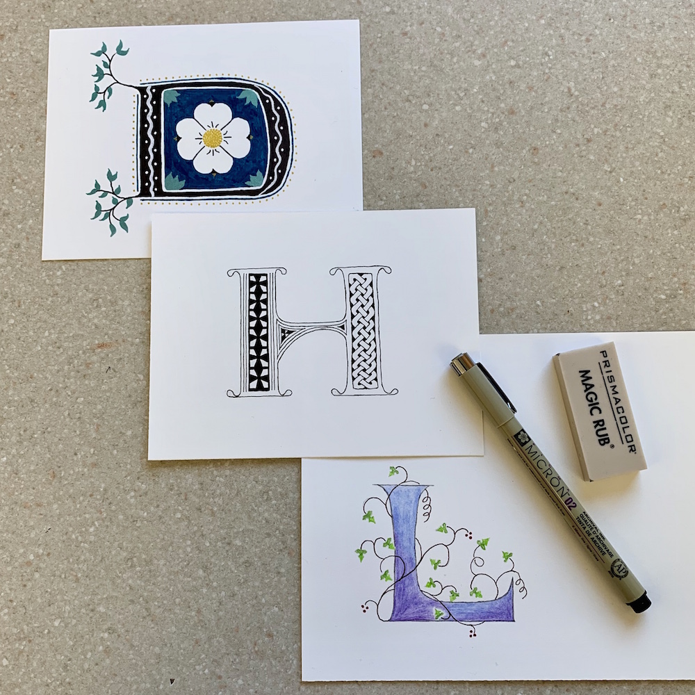 Three completed letters. D with the dogwood motif, H with Celtic knotwork and quatrifoils, L with Gothic ivy leaf vines.