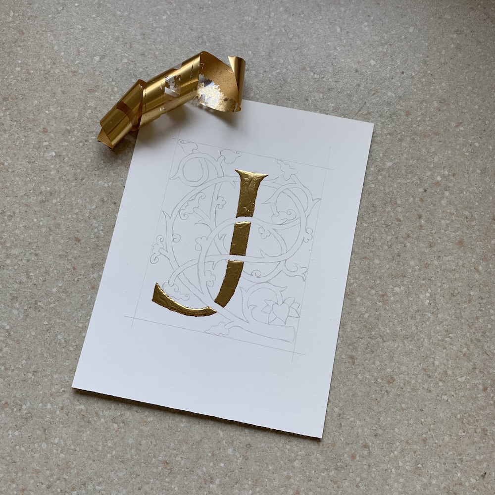 J with gold foil laid on it.
