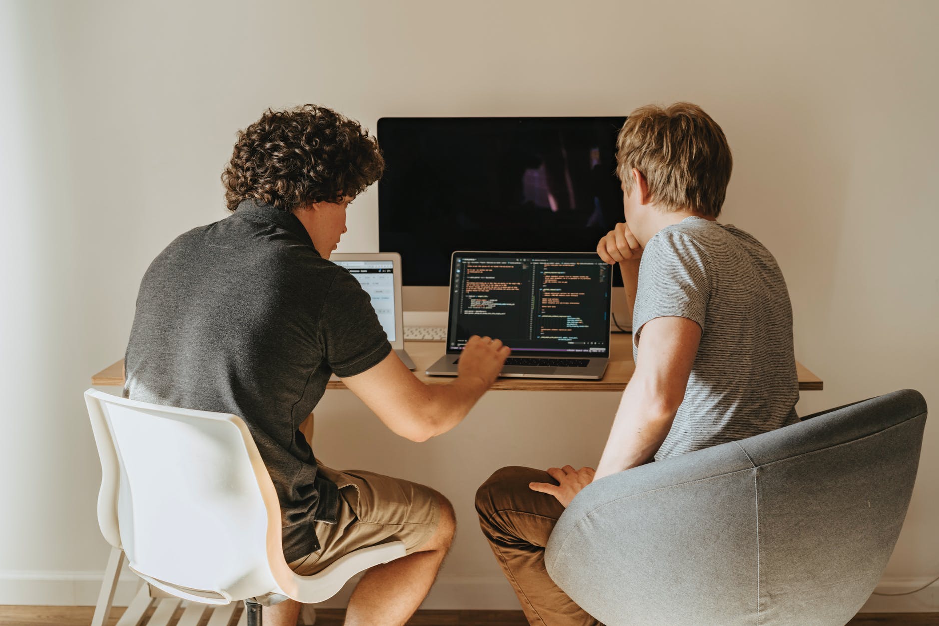 two men looking at a laptop