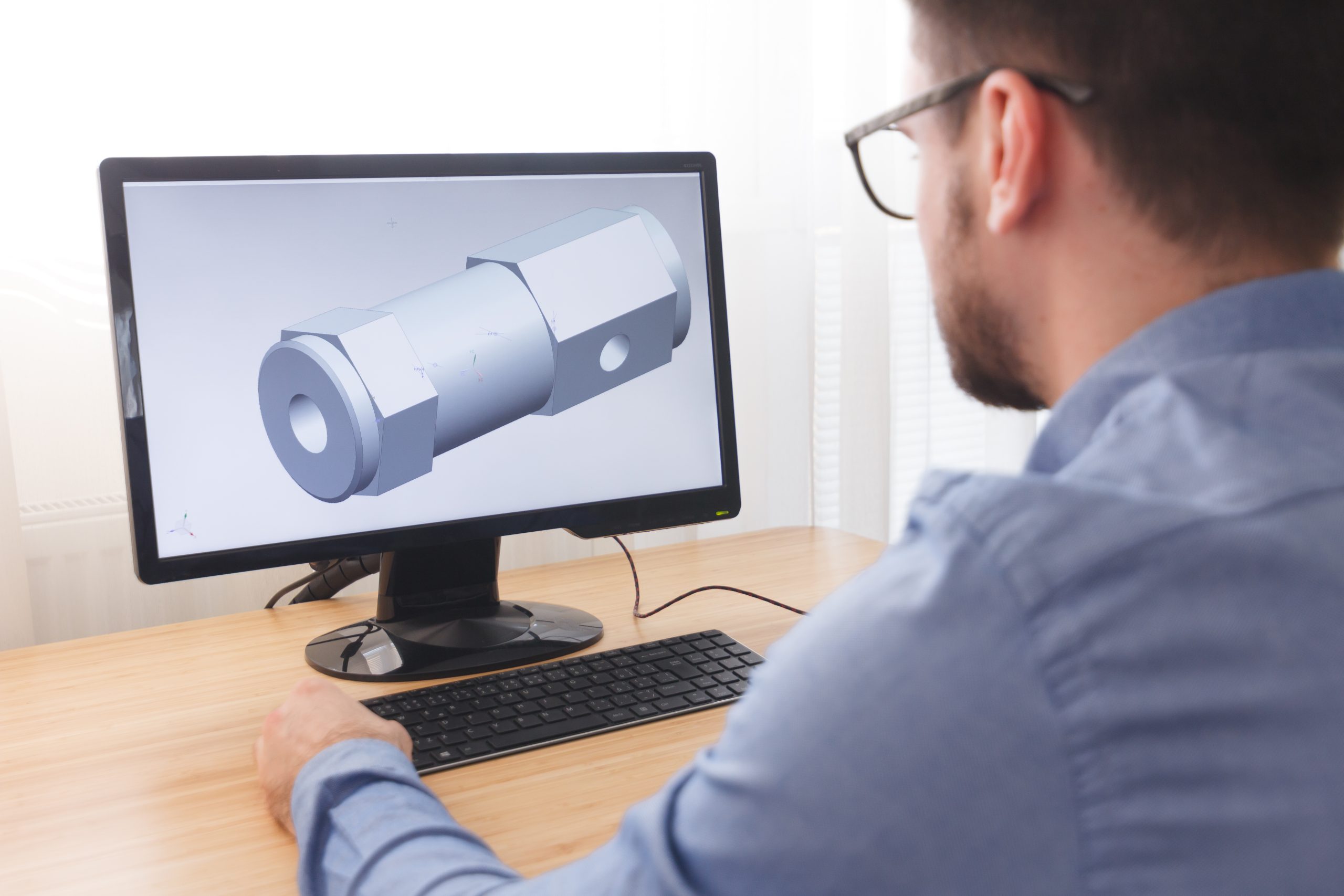 Engineer, Constructor, Designer in Glasses Working on a Personal Computer. He is Creating, Designing