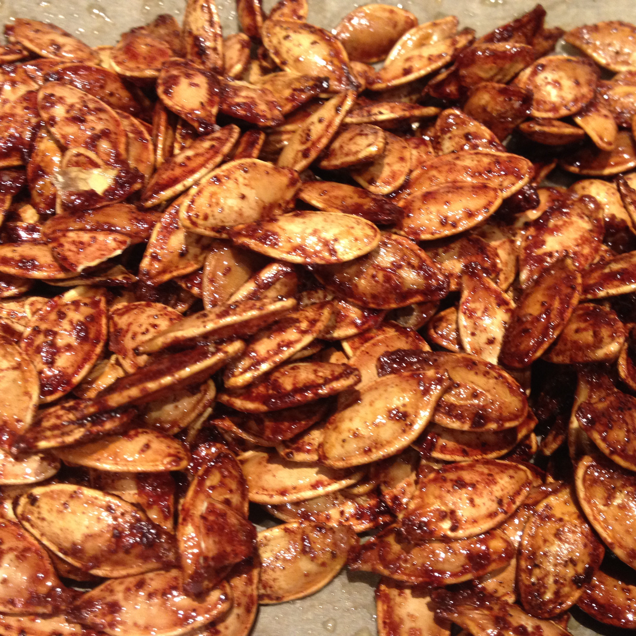 Ristede græskarkerner med sukker, kanel og olie.