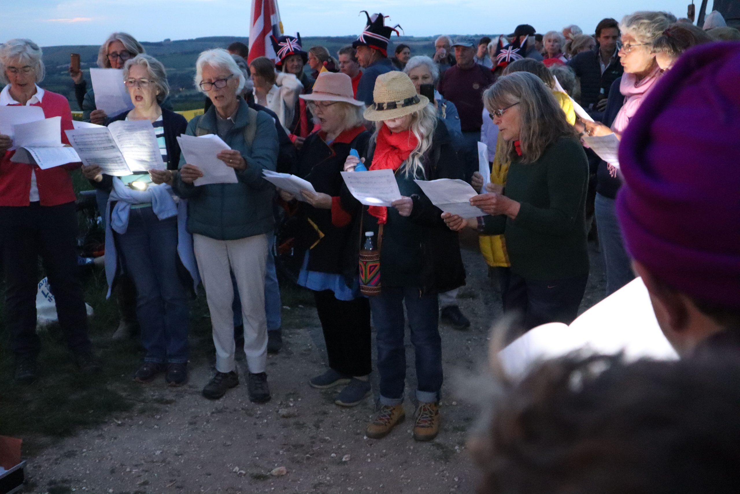 Group of casually dressed singers outside at dusk