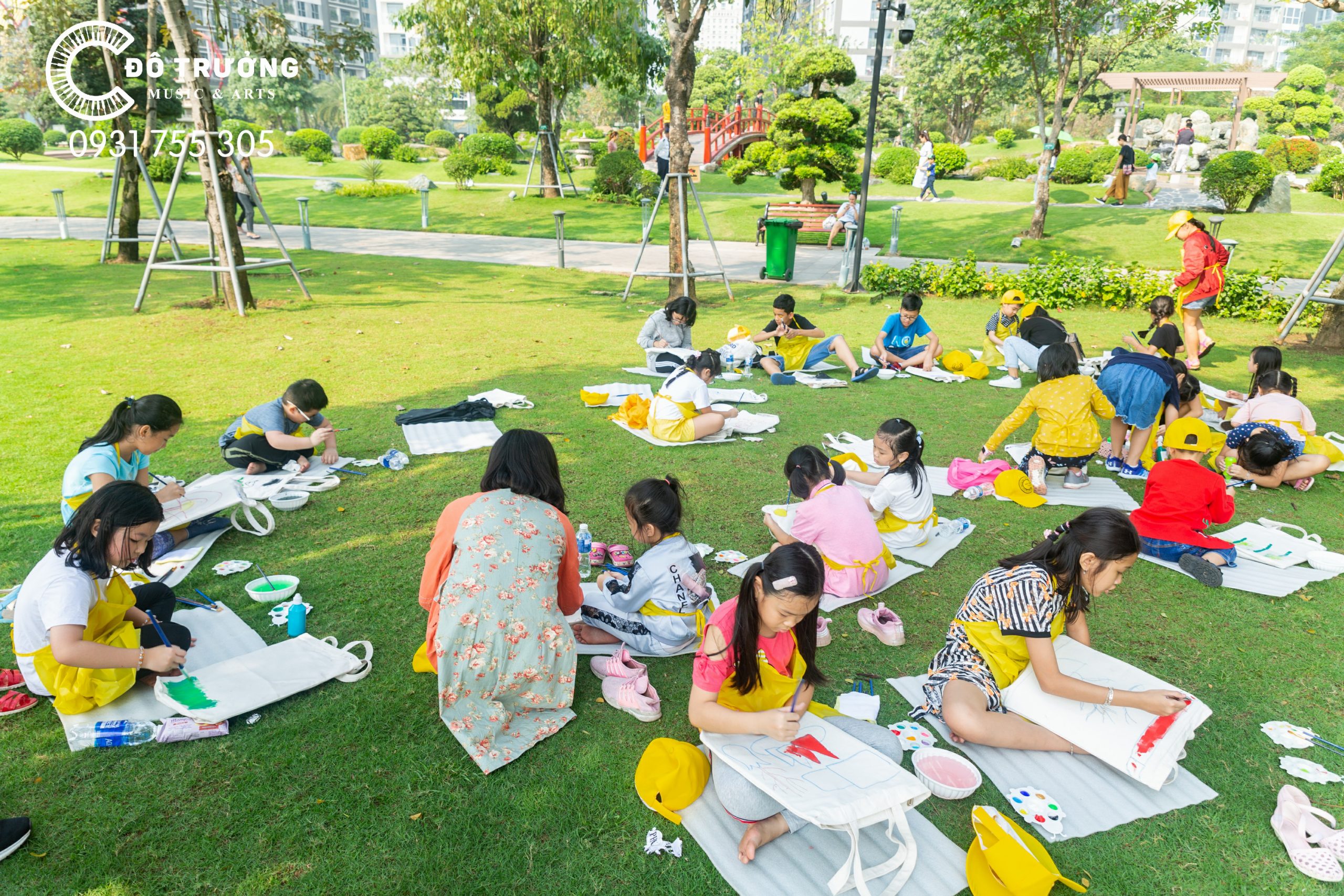 Các họa sĩ nhí ngồi tập trung, chuẩn bị dụng cụ để bắt đầu vẽ Landmark 81 trên túi vải