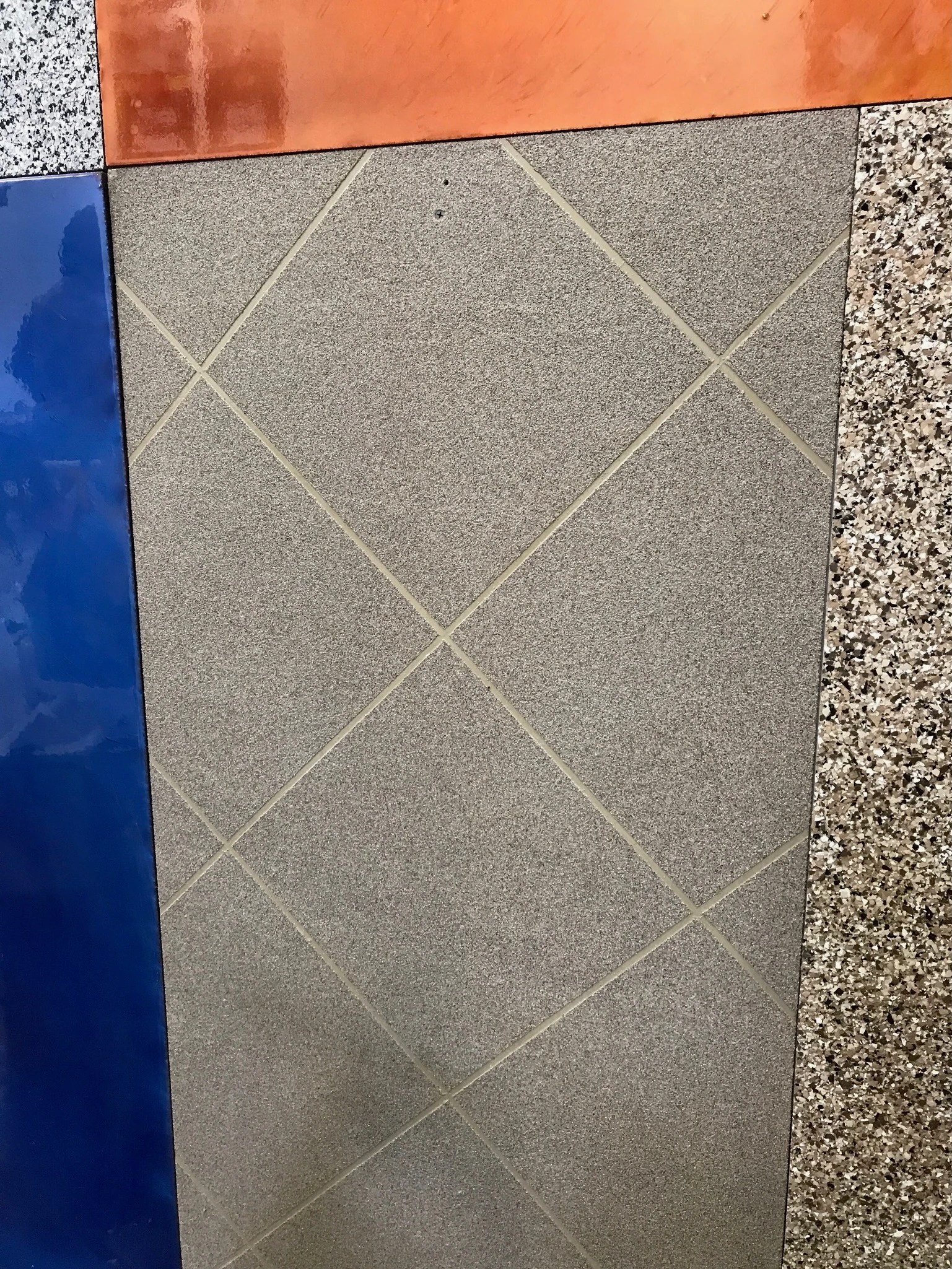 Gray speckled surface sample with a cream diamond pattern, bordered by blue, orange, and multicolored samples.