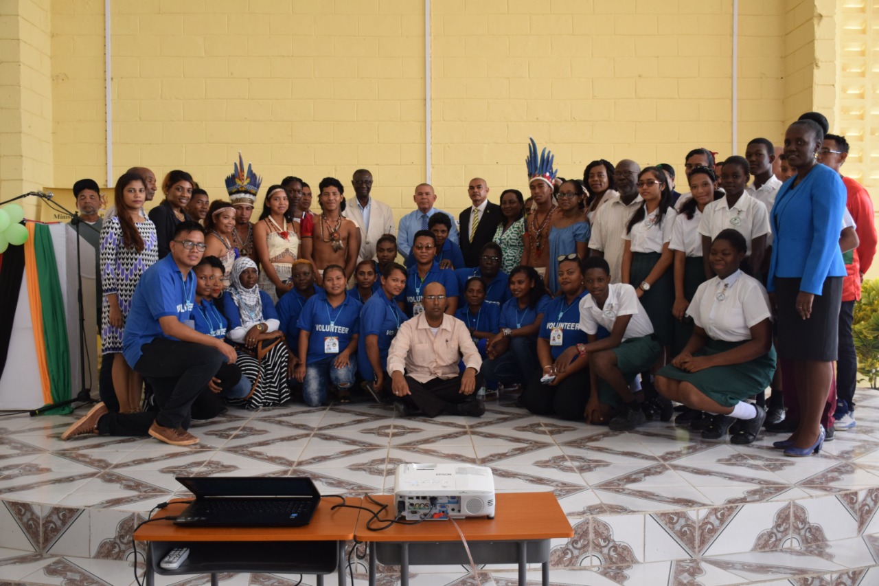 Minister of Social Cohesion, Dr. George Norton [centre], Regional Executive Officer, Rupert Hopkinson [left of the Minister], Coordinator of the programme, Shabbir Ali [sitting in the centre] along with other senior officials, participants, and volunteers of the Inter-Village Social Cohesion exchange programme