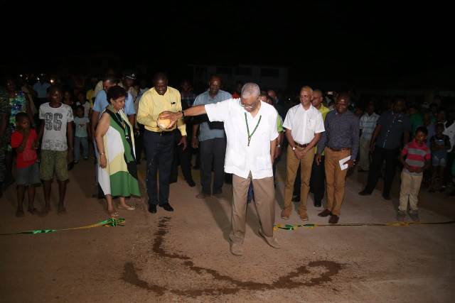 President David Granger bursts coconut as is the tradition as he declares Mahdia a town.