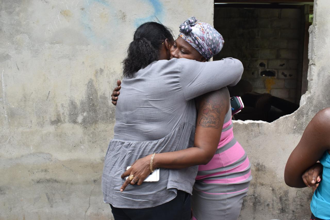 Minister Broomes consoles Natasha Cadogan who lost her home to a fire