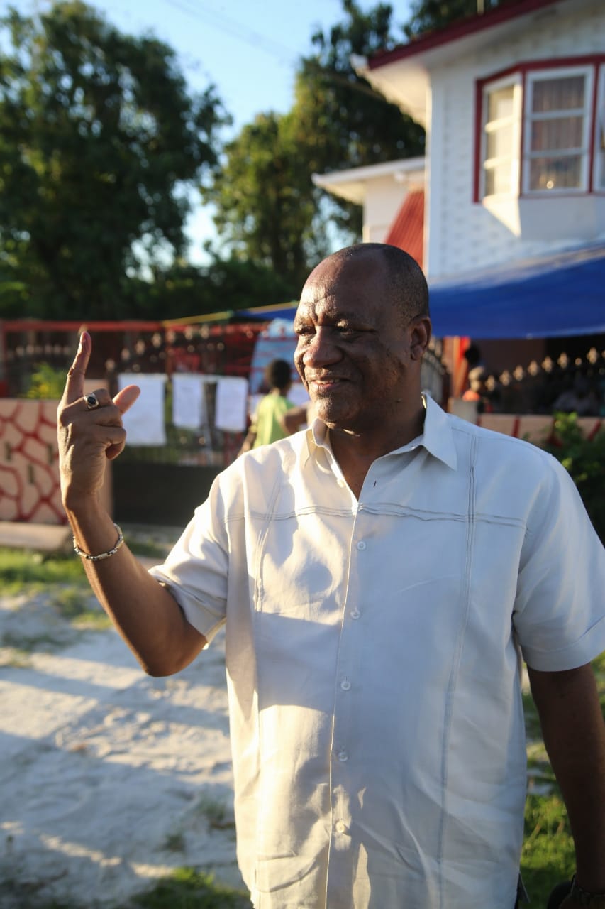 Minister of State, Joseph Harmon showing his inked finger after casting his vote