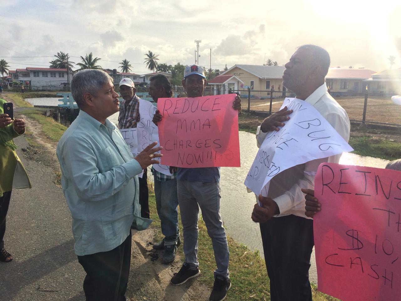 A government for all the people: Minister within the Ministry of Finance, Jaipaul Sharma interacting with some of the protestors outside of the meeting at the Latchmansingh Primary School.