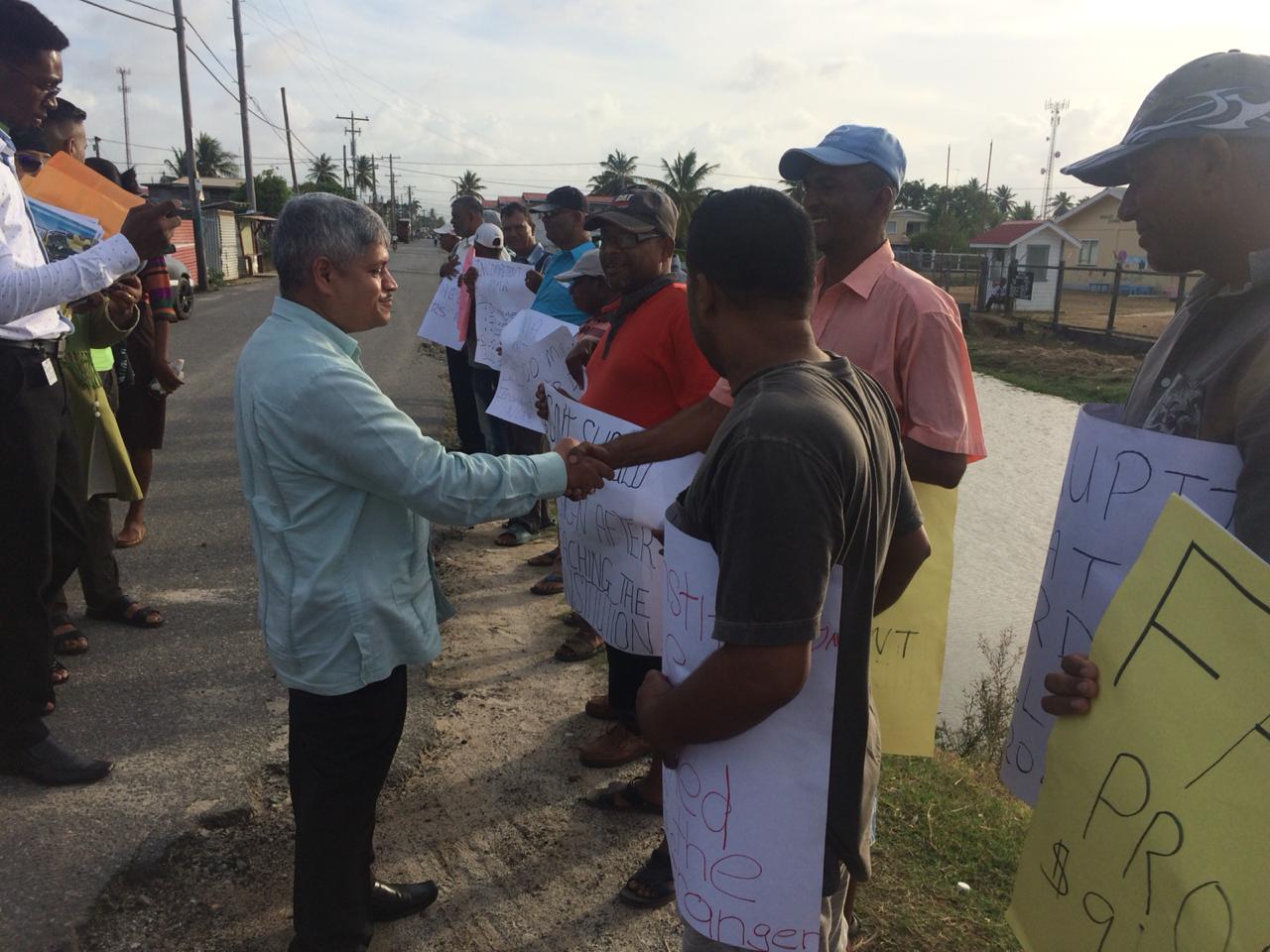 A government for all the people: Minister within the Ministry of Finance, Jaipaul Sharma interacting with some of the protestors outside of the meeting at the Latchmansingh Primary School.
