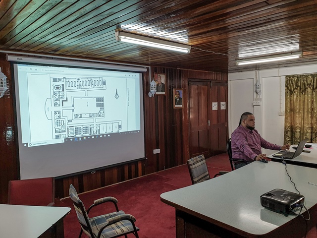 Consultant showing one of the plans of the new school.