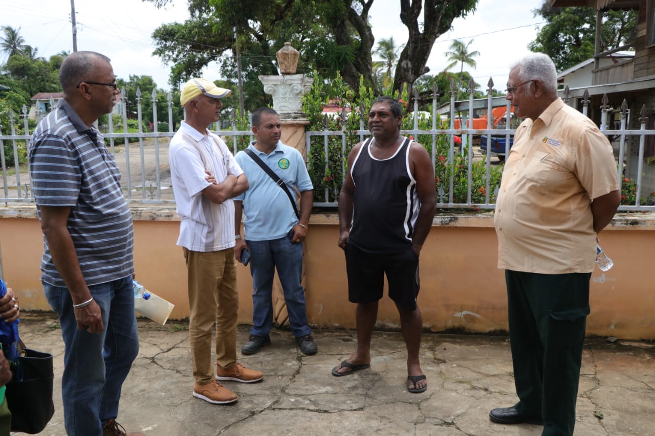Minister of Communities, Ronald Bulkan [second from left] and Minister of Agriculture, Noel Holder [right] interact with residents of Maria's Pleasure Wakenaam, earlier today. Also, accompanying the ministers was General Manager of the Guyana Rice Development Board, Nizam Hassan [extreme left]