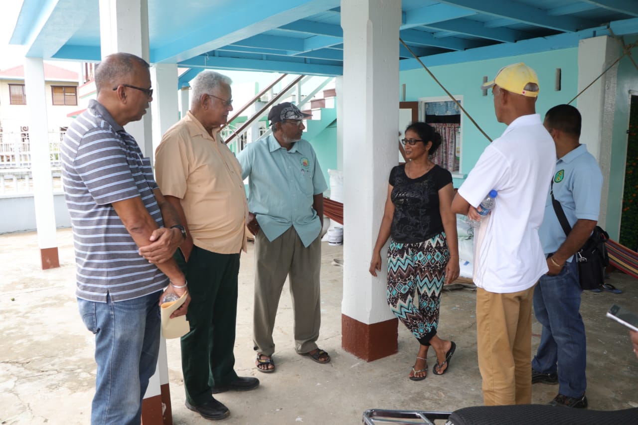 Ministers Holder and Bulkan and team engage with a resident at her home