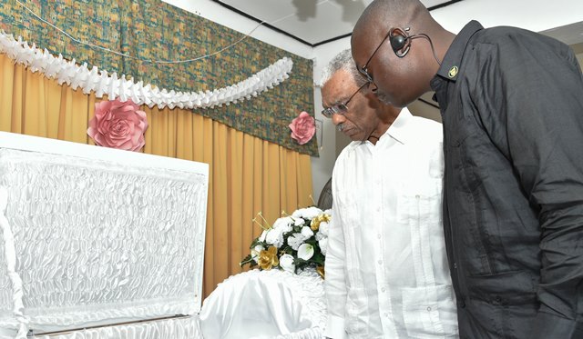 President David Granger views the body of the late Police Constable Winston Cooper. Also photographed is Mr. John Barker, Superintendent of Police.