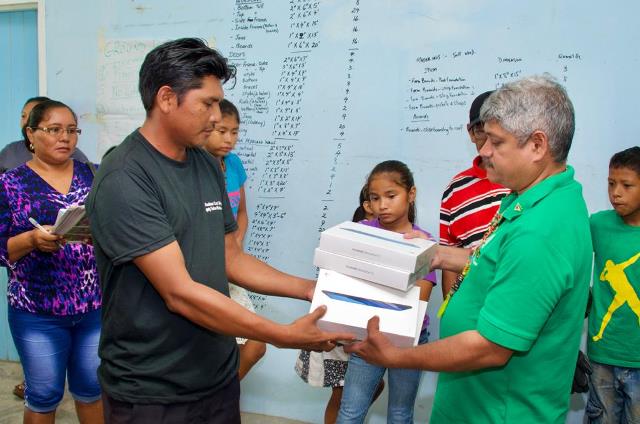 Minister Sharma hands over electronic tablets to the community.