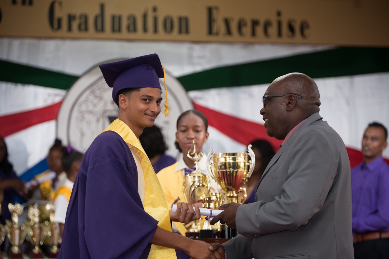 Best Graduating CSEC student, Kumar Persaud receiving prizes from the Chief Education Officer (CEO), Dr. Marcel Hutson.