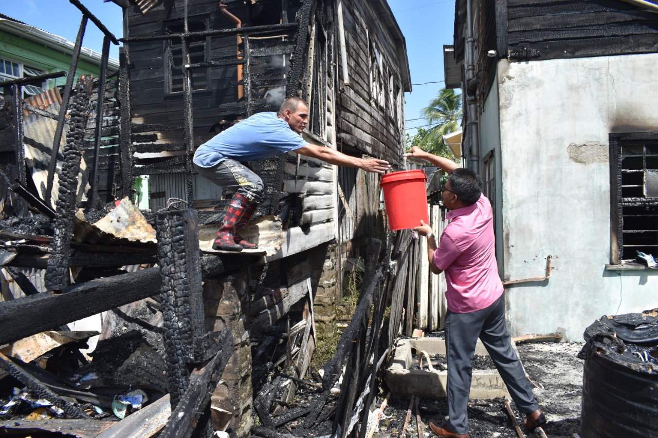 His Worship Pandit Ubraj Narine assisting a fire victim