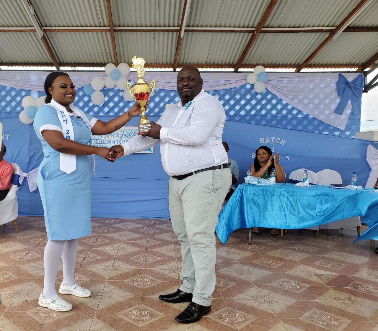 One of two valedictorians, Ayana George receiving her award from Director of Regional Health Services Region Six, Jevaughn Andrew-Stephen