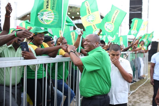 Director General of the Ministry of the Presidency, Joseph Harmon greets supporters as he makes his way to the stage.