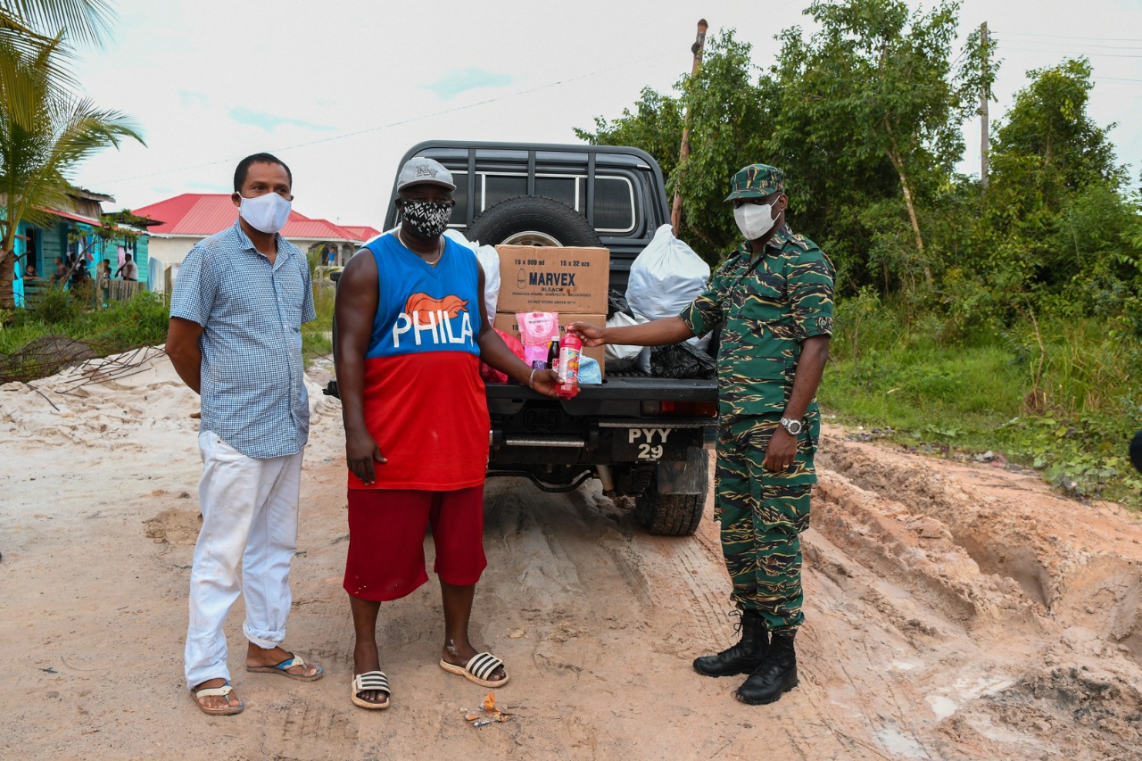 CDC Director General Lt. Col. Kester Craig hands over hampers to Byron Kendall, District Community Development Officer, Region 10