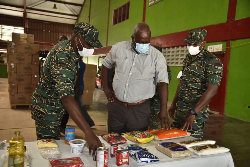 Prime Minister, Hon. (ret’d) Brigadier Mark Phillips is show some of the items that comprise the COVID-relief hampers during his visit to the CDC’s storage facility
