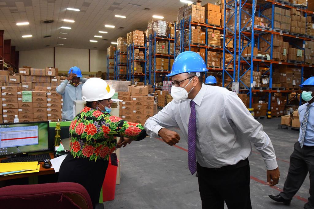 Minister of Health, Hon. Dr. Frank Anthony, greets the staff of the Supplies Chain Management Unit in Diamond, EBD in keeping with the COVID safety regulations