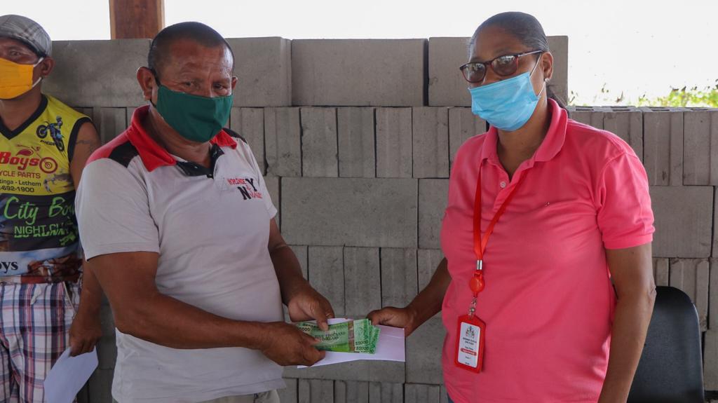A Region Nine resident receives his cash grant from Lethem Town Councillor Megan Thomas