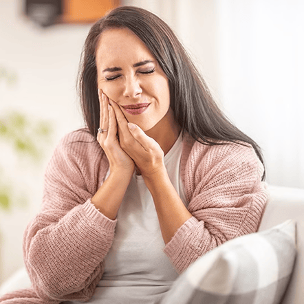 Woman experiencing tooth pain, potential sign needing root canal treatment in St. Petersburg, FL.