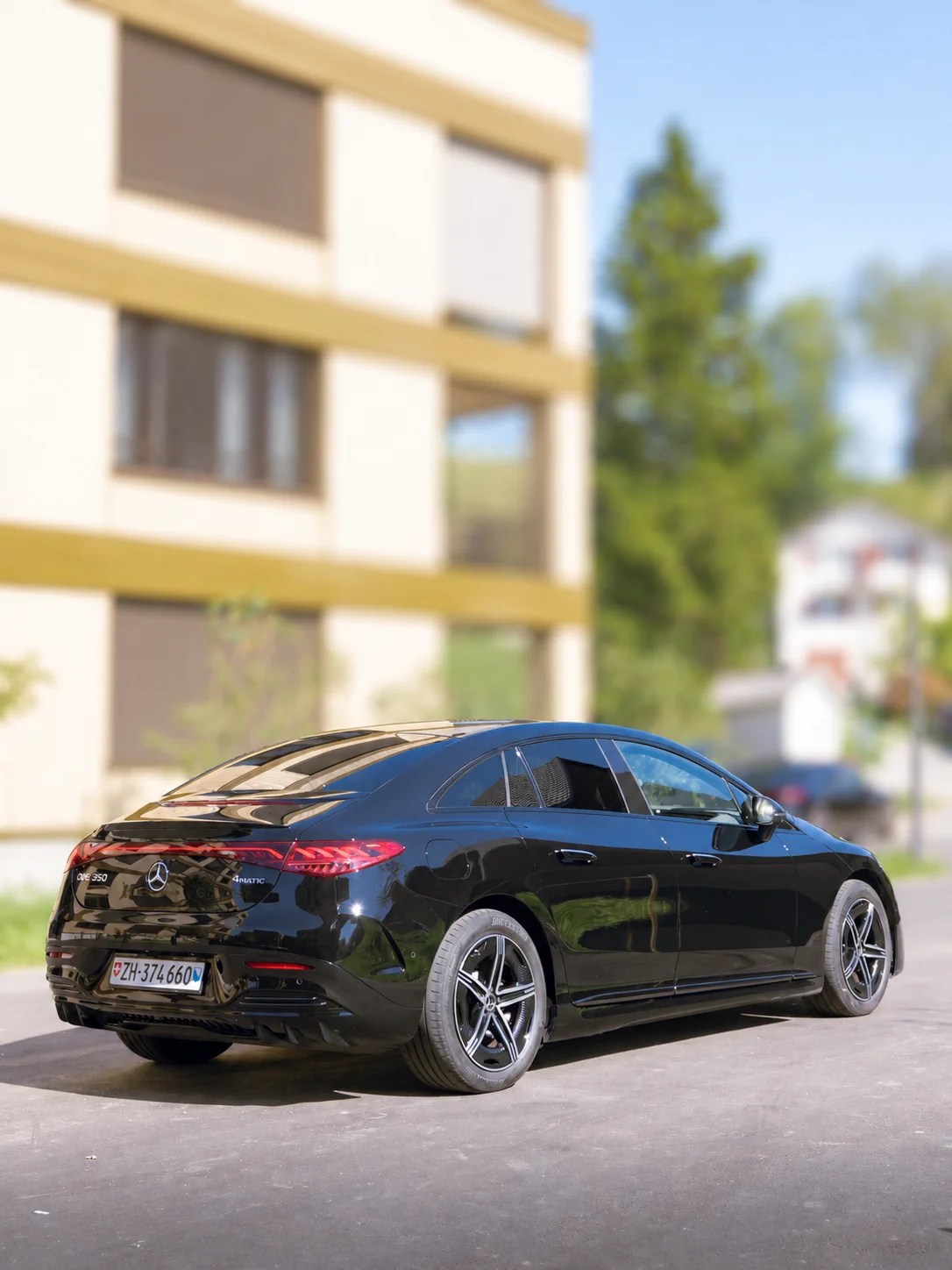 Black Mercedes EQE business sedan, rear three-quarter view