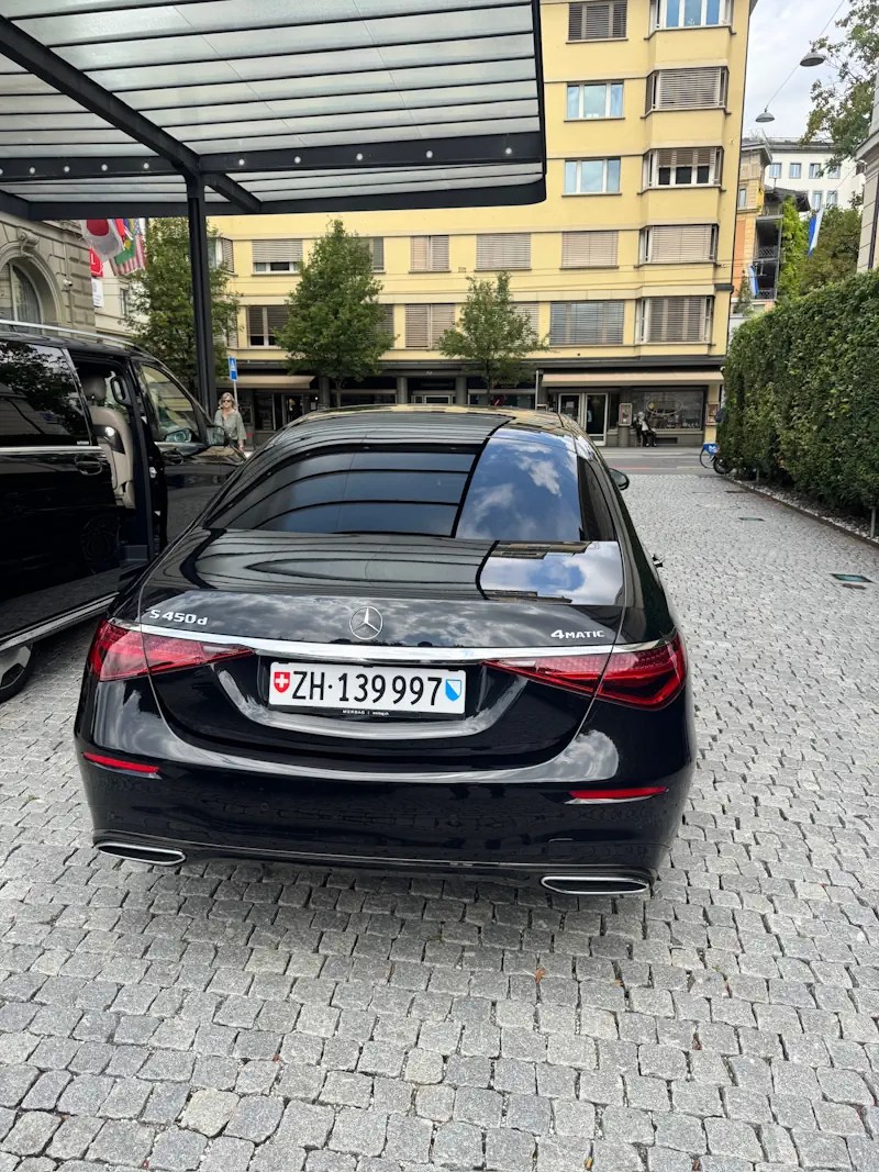 Schwarze Mercedes S-Klasse vor einem Hoteleingang, Heckansicht