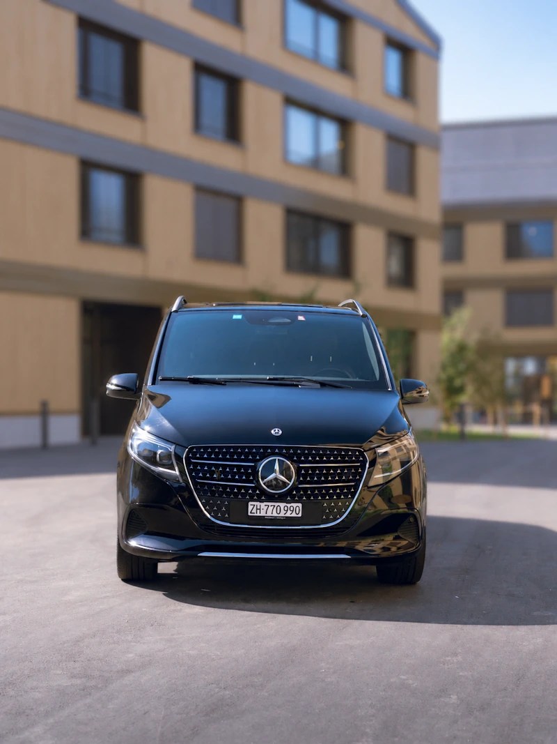 Black Mercedes V-Class van with driver, front view