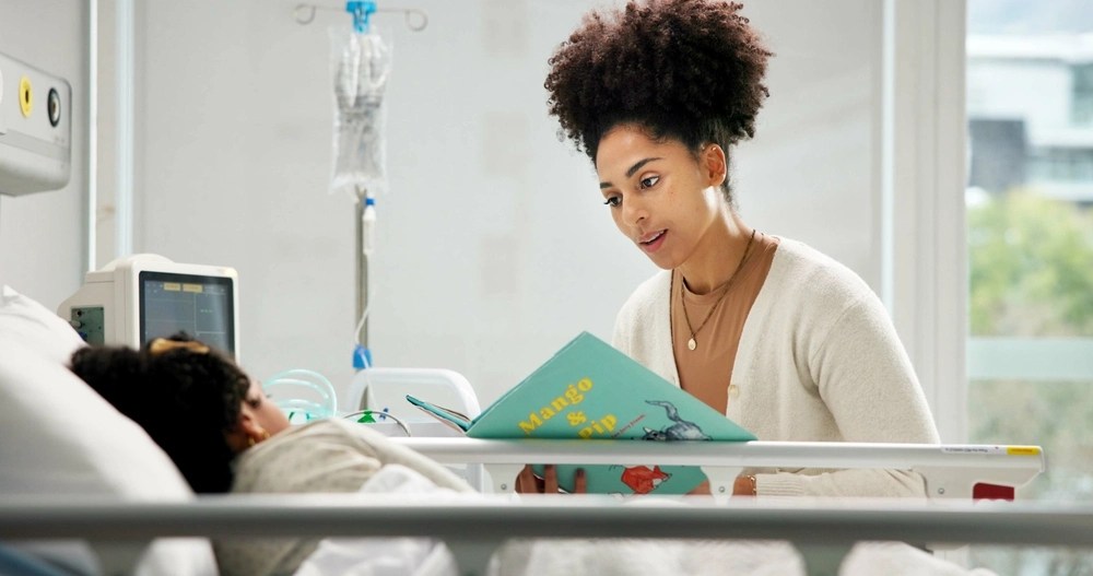 Mulher lendo livro para criança que está em recuperação no hospital