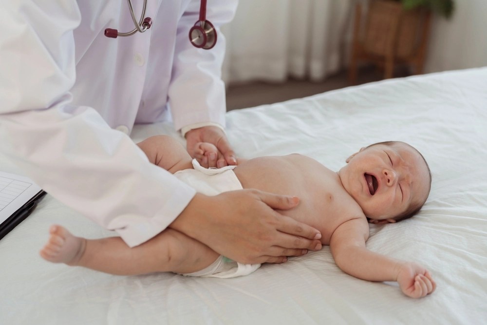 Médico examinando bebê deitado e chorando