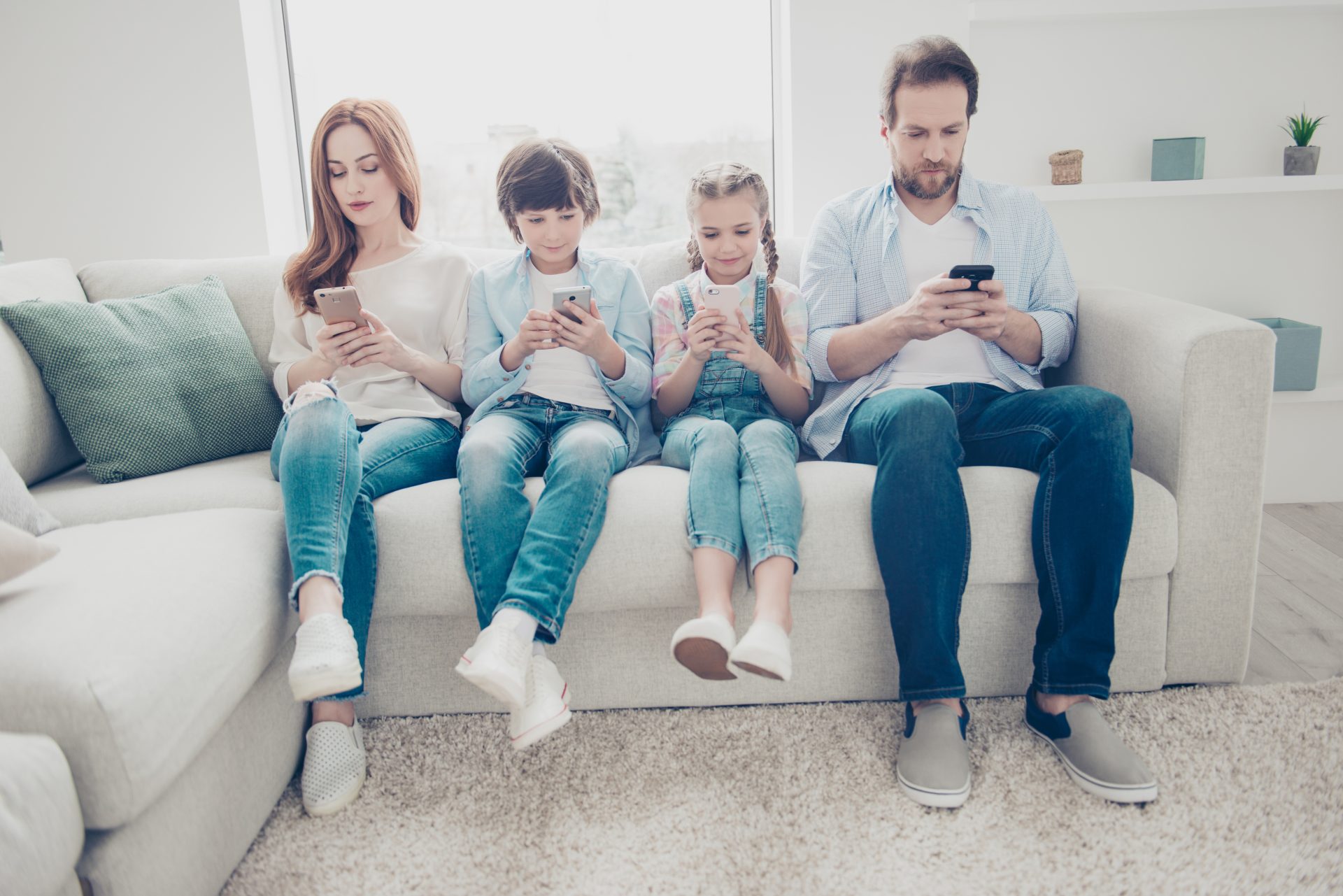 Portrait of family with two kids having holding smart phone electronic device.