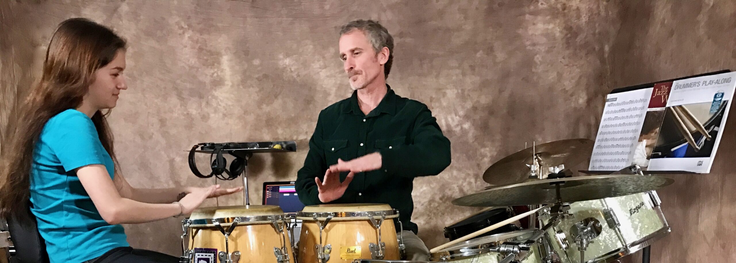Teacher and student playing drums